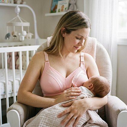 Maman assis sur un fauteuil et qui allaite son bébè et qui porte le Soutien gorge allaitement